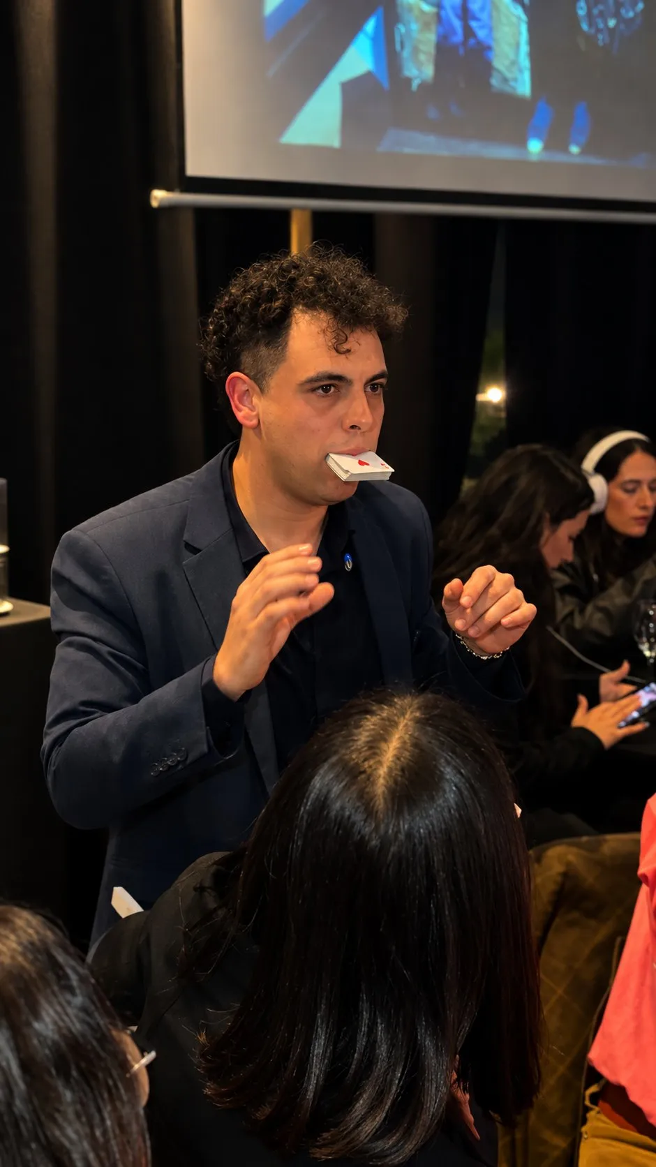 Facundo sostiene una carta con los dientes entre el público