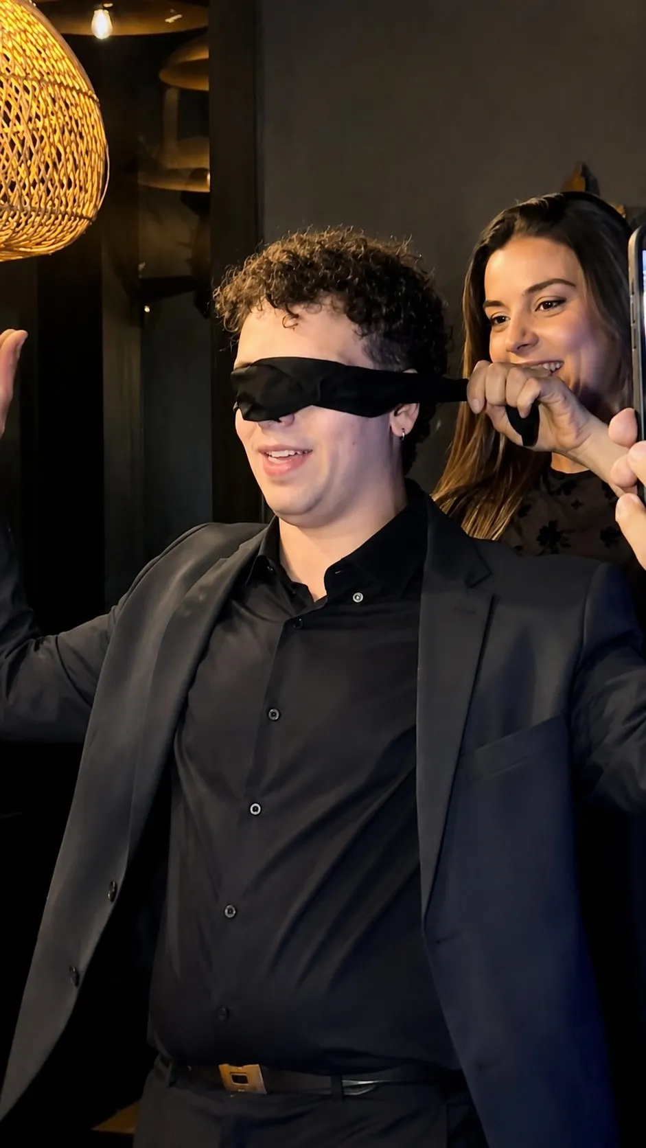 Facundo con los ojos vendados mientras una invitada lo guía